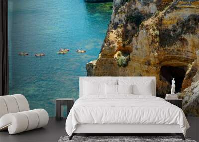 People group with kayaks and blue water..Rocky clifs of Ponta da Piedade at Lagos, Portugal. Wall mural