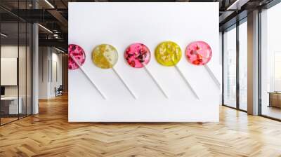 pink and yellow lollipops with pieces of fruit alternating in color laid out in a row Wall mural