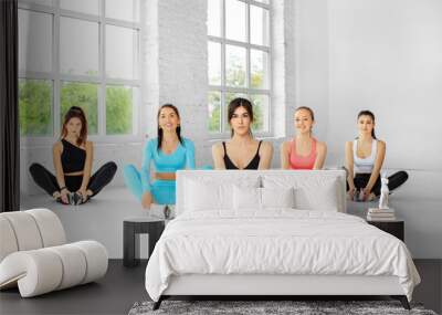 A group of women are engaged in stretching in the gym. The concept of sports, healthy lifestyle, fitness, stretching Wall mural