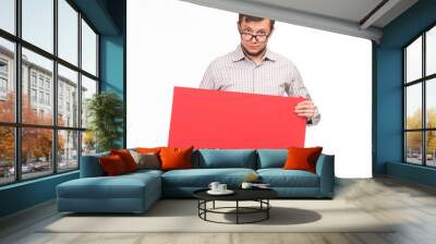 Young surprised man portrait of a confident businessman showing presentation, pointing paper placard gray background. Ideal for banners, registration forms, presentation, landings, presenting concept. Wall mural