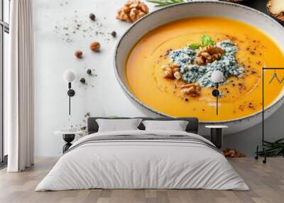 Pumpkin soup with blue cheese, nuts and herbs on white background Wall mural