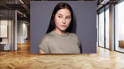 emotional portrait of charming brunette woman in marsh color t-shirt on grey wall background. actress acting, emotion Wall mural