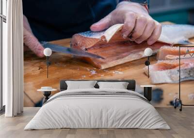 Chef preparing a salmon fish by gutting and filleting at the kitchen Wall mural