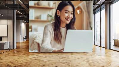 Attractive young Asian woman sitting in a cafe working at her laptop. Freelance distant work business management concept Wall mural