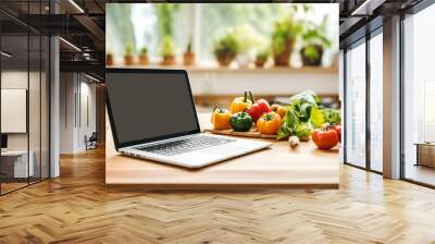 Open laptop with blank black screen sitting on wooden kitchen table. Fresh organic vegetables. Home cooking healthy diet concept Wall mural