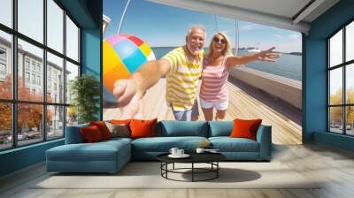 Happy couple on houseboat patio with beach ball Wall mural