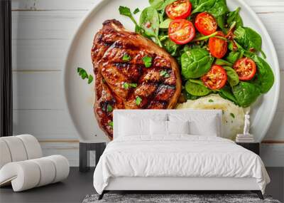 Grilled pork steak marinated in spicy sauce with mashed potato and fresh spinach on plate on white wooden table, horizontal view from above, flat lay Wall mural