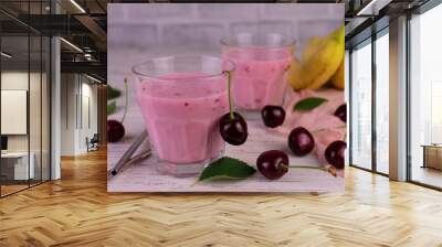 Two glasses of cherry and banana smoothie on a white wooden background.	 Wall mural