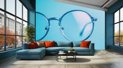 Round eyeglass lenses filling the entire light blue background Wall mural