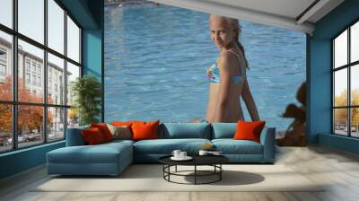 Teenage blonde girl sit in pool and smile Wall mural