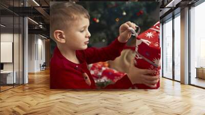 child unwraps a Christmas present Wall mural