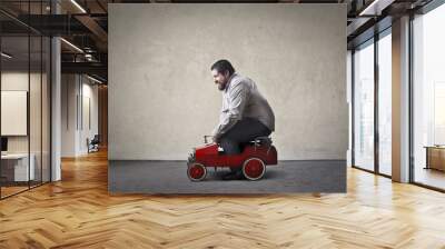 Chubby man driving toy car Wall mural