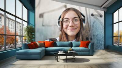 portrait of young girl with glasses and headphones Wall mural