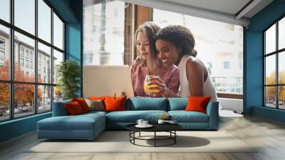 two young girls use a computer inside a cafe Wall mural