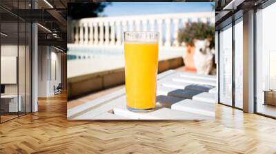 Freshly squeezed orange juice in the summer with views on swimming pool and the sea, glass of orange juice Wall mural