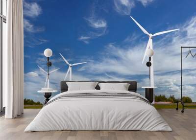 A group of windmills for generating renewable electricity against a sky background with beautiful clouds Wall mural