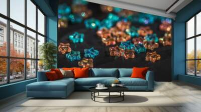 Star-shaped multicolored beads are scattered on a black background. Needlework materials close-up. Wall mural