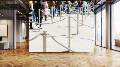 stainless steel poles linked by grey ropes for queue control at the entrance of a tourist site, with Wall mural