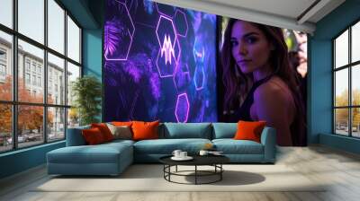 Young woman admiring vibrant digital art display at an evening event outdoors Wall mural