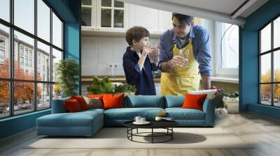 Father and son cooking in kitchen Wall mural