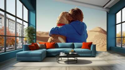 A boy in a blue sweatshirt hugs a dog
 Wall mural