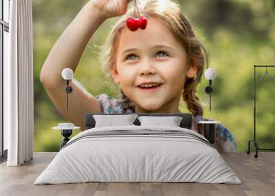 little girl holding a basket of cherries on nature in summer Wall mural