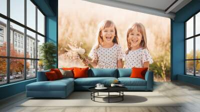 Two little happy identical twin girls playing together in nature in summer. Girls friendship and youth concept. Active children's lifestyle. Wall mural