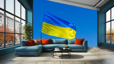 Blue-yellow flag of Ukraine on blue sky background Wall mural