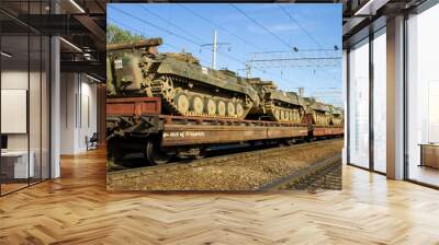 Cargo train carrying military tanks on railway flat wagons Wall mural