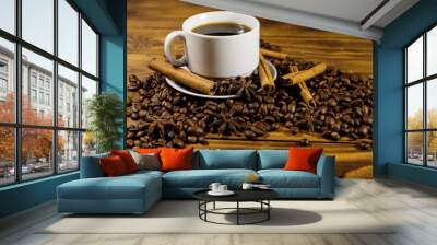 Cup of coffee, roasted coffee beans, star anise and cinnamon sticks on wooden table Wall mural