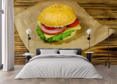 Fresh delicious homemade cheeseburger on brown paper on wooden table Wall mural