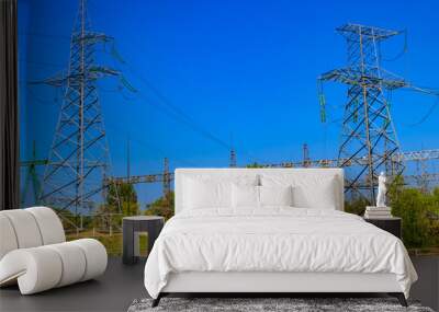 High voltage power lines towers on blue sky background Wall mural