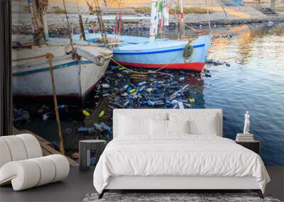 Old boats moored in dirty harbour. Pollution of river, sea, ocean water with waste, plastics garbage. Concept of pollution of ocean, sea and river coastline with plastic trash Wall mural