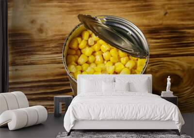 Open tin can of corn on wooden table Wall mural