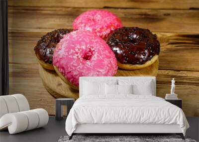 Tasty pink and chocolate donuts on a wooden table Wall mural