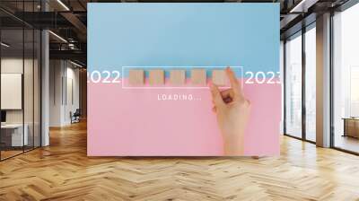 Female hand putting wooden cube for countdown to 2022. Loading year from 2022 to 2023. New year start concept Wall mural