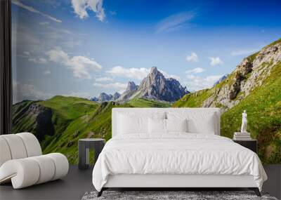 Young man with backpack on a mountain trail, Dolomites Mountains, Italy Wall mural