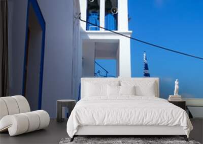 Stepped front of a white and blue Orthodox church with bell tower and Greek flag Wall mural