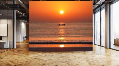 Sunset on the orange-coloured beach reflected in the sea, a fishing boat on the horizon. Wall mural