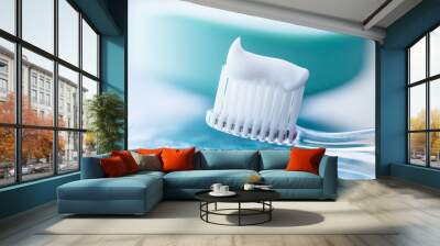 Plastic toothbrush with white toothpaste on a blue table Wall mural