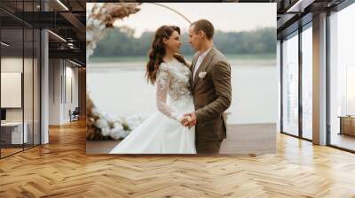 the first wedding dance of the bride and groom on the pier near the river Wall mural