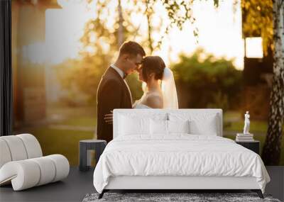 young couple the groom in a black suit and the bride in a white short dress Wall mural