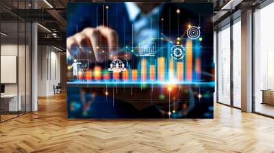 A business professional interacts with a digital screen displaying financial analytics and growth charts. The image highlights the use of advanced technology in business analysis and decision-making. Wall mural