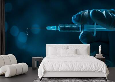 Close-up image of a syringe dripping a drop of vaccine, held by a gloved hand, emphasizing precision in medical treatment. Wall mural