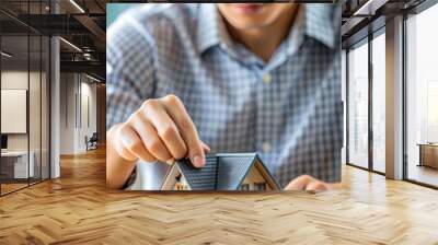 close up young man hand touching house's model for check and summary expense of home loan mortgage for refinance plan , people lifestyle concept Wall mural