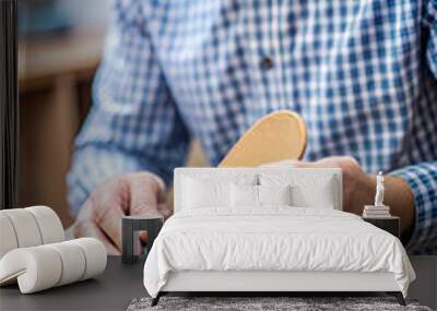 Man putting orthopedic insole into shoe at home, closeup Wall mural