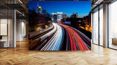 Curved Motorway A40 called “Ruhrschnellweg“ at blue hour after sunset in Essen City Ruhr Basin Germany with six lanes, bright light traces, sky gradient and skyline silhouettes of office towers. Wall mural