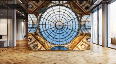 Glass roof in historic public gallery passage in Milan, Italy. Symmetric vertical view from the centre of the traditional shopping mall, major attraction in town. Sunshine and blue sky above cupola. Wall mural