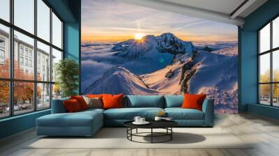 Stunning sunset or sunrise in winter alpine like snow landscape. Inversion, sun star peaking behind high rocky and icy summit. Purple, pink, blue and orange colors. Ladovy stit in winter High Tatras. Wall mural