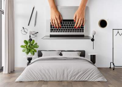 Female hands using laptop on white background with coffee cup and accessories. Office desktop. Top view Wall mural